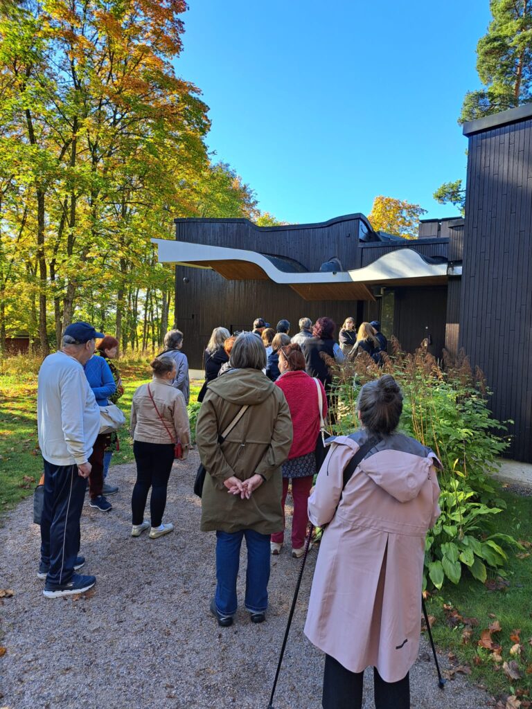 Joukko ihmisiä menossa sisään taloon.