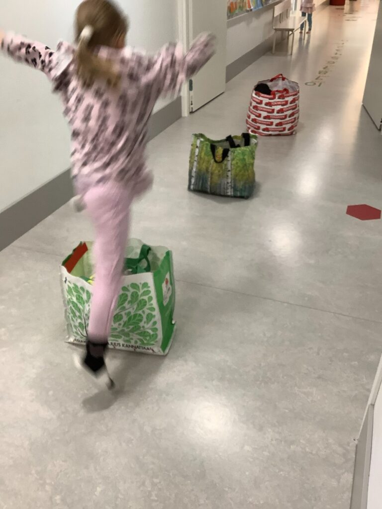 Kestokasseista rakennettu esterata, lapsi hyppii kassien yli.