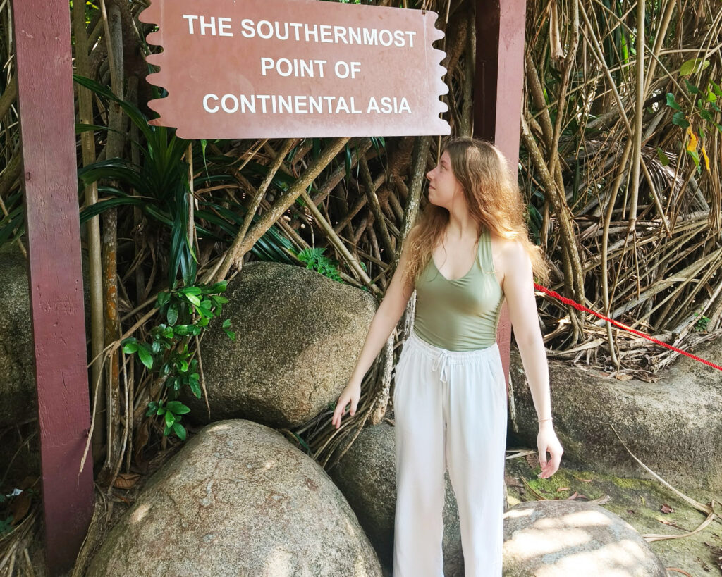 Linnea katsoo takanaan olevaa kylttiä, jossa lukee "The southernmost point of continental Asia". 