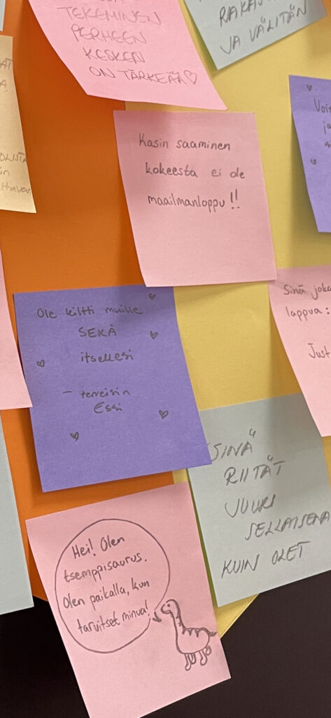 Värillisiä post-it -lappuja, joissa erilaisia kannustuslauseita.