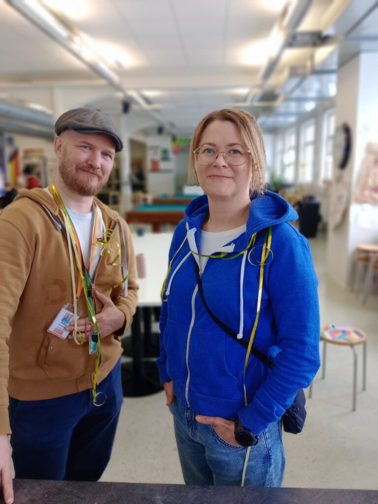 Huppariasuiset mies ja nainen kuvassa. Takana näkymää nuorisotalon tiloista.