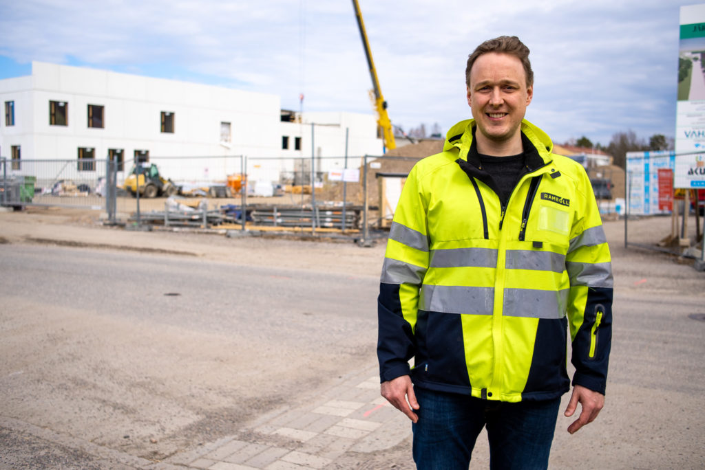 Magnus Stägnas seisoo kuvassa oikealla JYK-rakennushankkeen edessä, työmaa kuvassa takana.