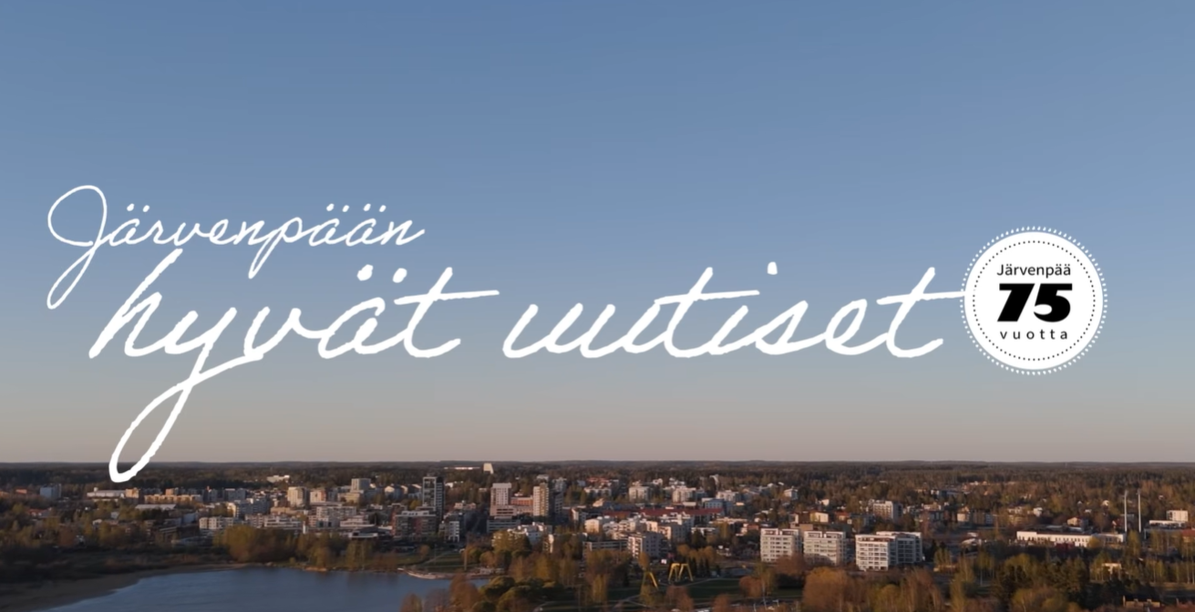 Kuvassa näkyy ilmakuva Järvenpäästä. Kuvan päällä lukee käsinkirjoitetulla tyylillä: “Järvenpään hyvät uutiset” Oikeassa reunassa on pyöreä logo, jossa lukee: “Järvenpää 75 vuotta”