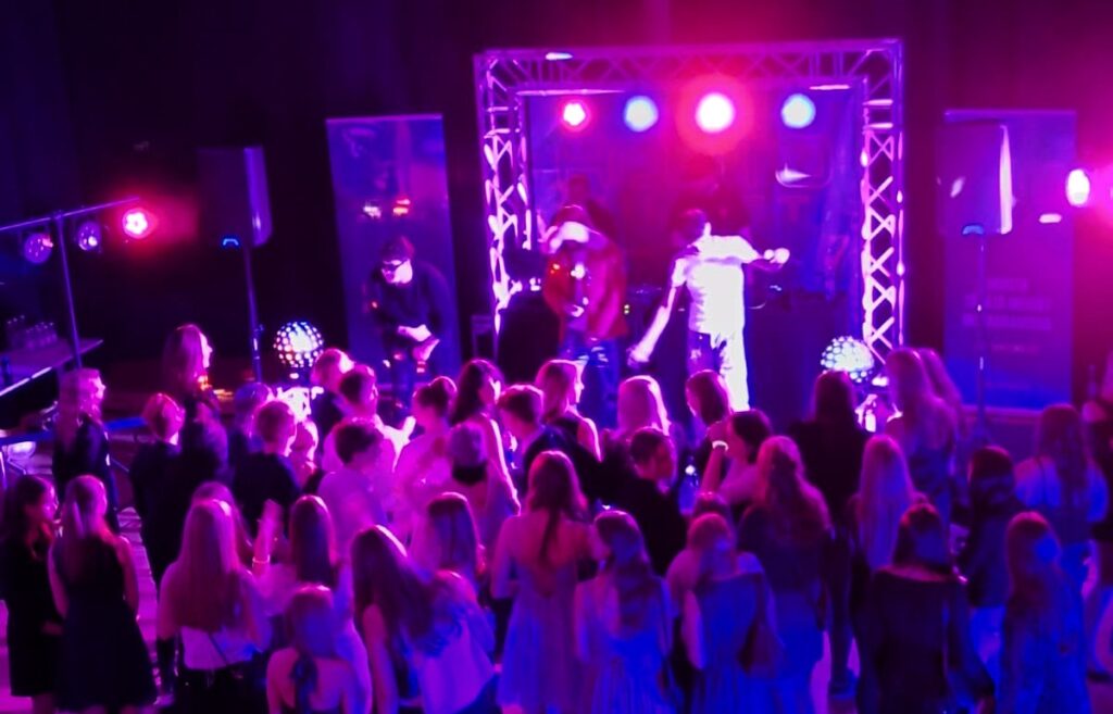 Nuoret tanssivat discossa. Tilassa on hämärä discovalaistus.